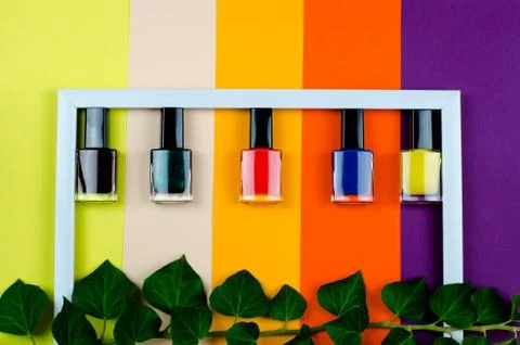 Nail polish of different colors inside a white frame top view Stock Photos