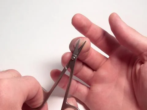 Nail scissors in the process of cutting nails on a man's hand Stock Photos