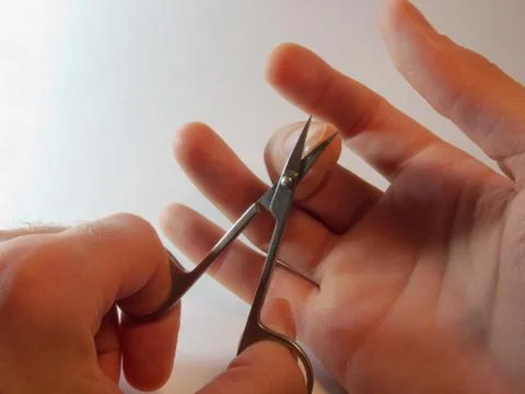 Nail scissors in the process of cutting nails on a man's hand Stock Photos
