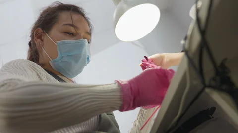 Nail Technician Applying Hardener to Client Thumb from Downward Angle Stock Footage 310270394