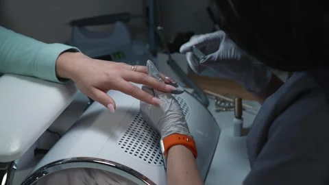 Nail technician creates magnetic pattern in glitter gel Stock Footage 343802643