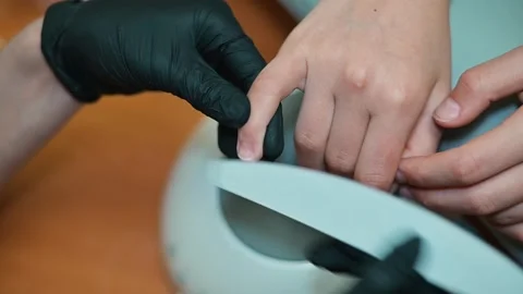 A nail technician performs a filing procedure on a client's nails in a beauty Vidéo 338447043