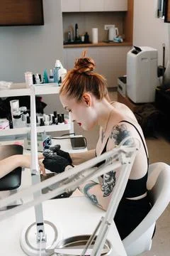 Nail technician uses an electric drill while working on a clients fingernai.. Stock Photos