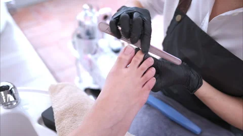 A nail technician is using tools to polish nails of a customer Video stock 278506542