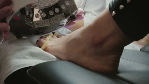 Nails on the feet of the client are dried under a lamp in the beauty salon 库存影片 101631739