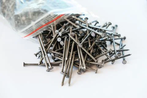 Nails fell out of the packaging. Nails on a white isolated background Stock Photos