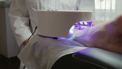 The nails on the model's foot are dried using led lamp, nail dryer Stock Footage 101096839
