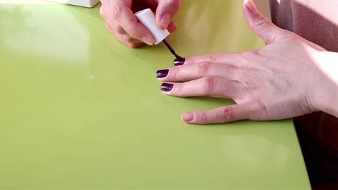 Nails polish, dark red nails, on green backgraound, manicure do yourself 스톡 동영상 73389354