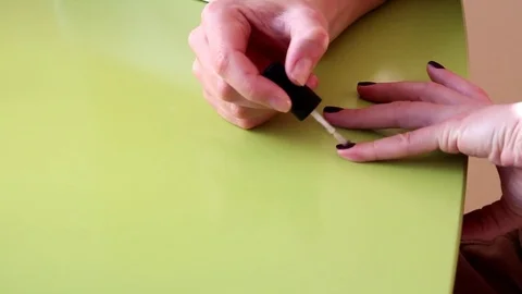 Nails polish, dark red nails, on green backgraound, manicure do yourself Vídeos de archivo 73389408