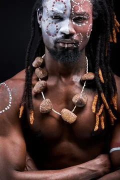 Naked black man with shaman aborigen make-up confidently looking at camera Stock Photos