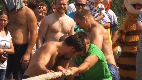 Naked men pull the rope.Traditional holiday entertainment in Belarus.Belarus/Osh Stock Footage 127557862