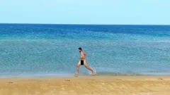 Hundreds of nudist people running into the sea naked