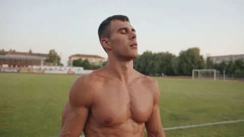 A naked torso bodybuilder training in the stadium and rests between exercises Stock Footage 157312134