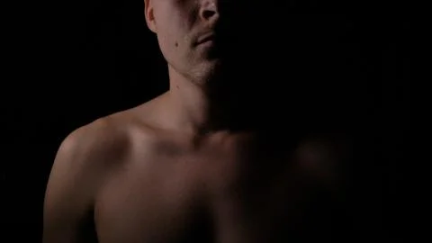 Nakked man posing in studio. Short haired model man with muscular body looking Stock Photos
