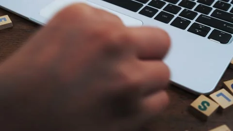 Name of the month March beeing created from wooden letter tiles on computer desk Stock Footage 171641060