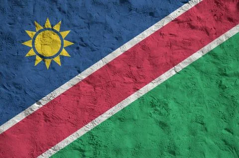 Namibia flag depicted in bright paint colors on old relief plastering wall. T Stock Photos