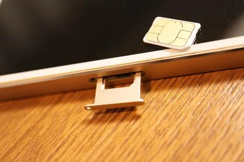 Nano SIM card placed on a smartphone screen with the open SIM card tray slo.. Stock Photos