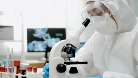 A nanotechnologist examines tiny microscopic structures under a microscope. Stock Footage 336583686
