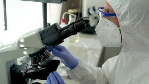 A nanotechnologist examines tiny microscopic structures under a microscope. Stock Footage 336583689