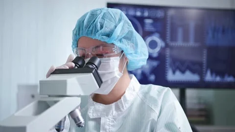 A nanotechnologist examines tiny microscopic structures under a microscope. Stock Footage 336583743