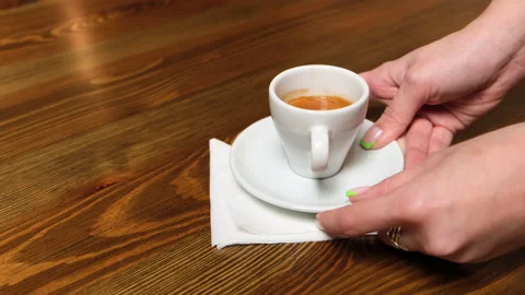 A napkin is laid out on the table, espresso and a glass of water are placed. Stock Footage 158178485