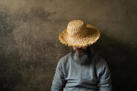 A napping man with a beard in a hat against the background of a wall Stock Photos