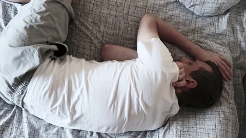 NAPs. Top view of young man in white t-shirt, tumbling in dream on other side Video stock 135743745