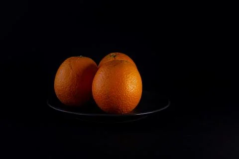  naranjas frescas sobre fondo negro Stock Photos