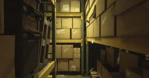 Narrow aisle in a storage facility filled with stacked cardboard boxes Stockillustratie