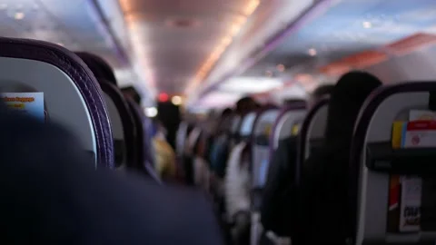 Narrow aisle view inside airplane cabin with full of passenger while relaxi.. Video stock 228860970