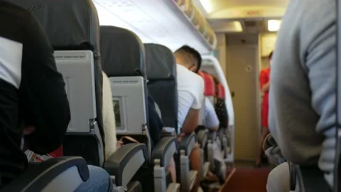 Narrow aisle view inside airplane cabin with full of passenger while relaxi.. Video stock 236119332