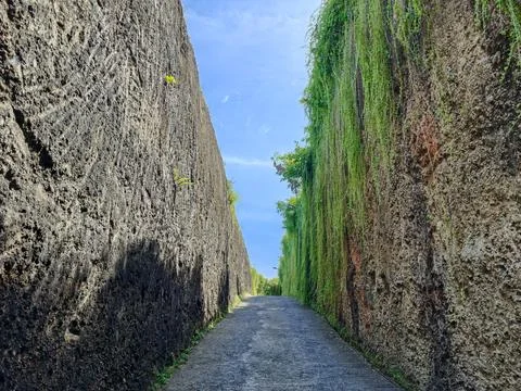 Narrow asphalt path between high limestone cliffs Foto stock