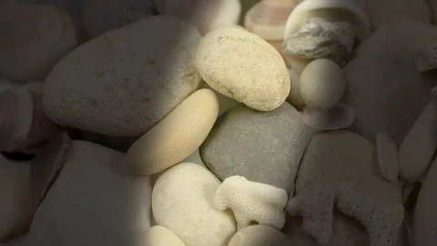 A narrow beam of light glides over sea pebbles 動画素材 118708999