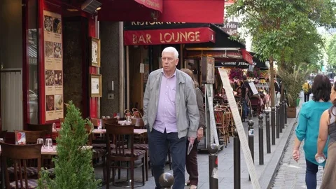 Narrow beautiful cozy street Paris Latin quarter people walking along frontages Stock Footage