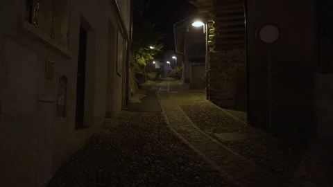 Narrow empty cobblestone street at night in old Italian mountain village Stock Footage 325806157