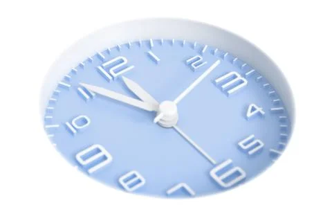 Narrow focus to clock with time 5 to 12 or 11.55 AM PM, blue clock face, on w Stock Photos
