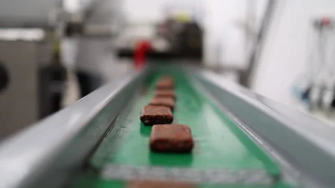 Narrow focus closeup: Date bars on facility conveyor roll to camera Stock Footage 305134368