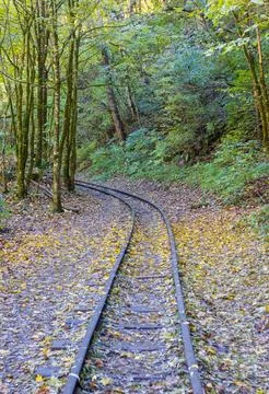 A narrow gauge railway with a solid foundation in a mountainous area in early Stock Photos