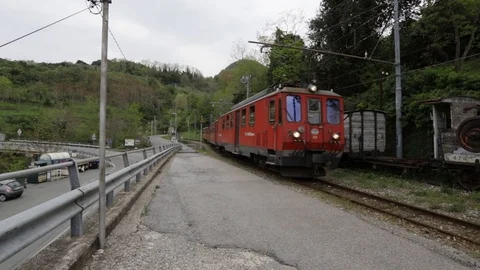Narrow-gauge red train passes in the countryside Stock Footage 106836693