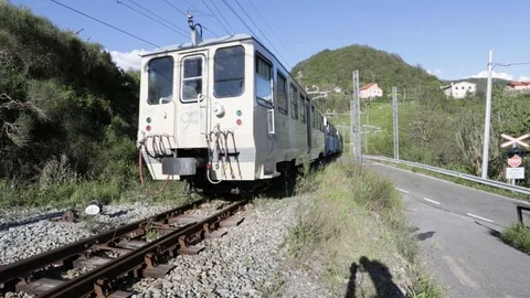 Narrow-gauge train runs a level crossing in the countryside Stock Footage 107121127