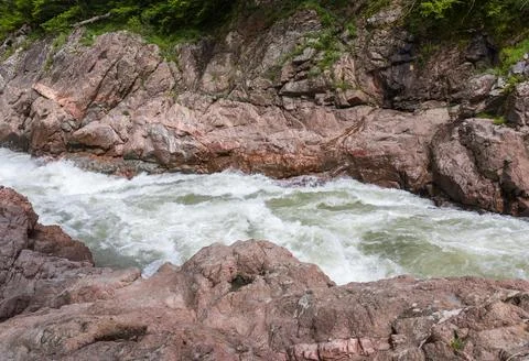 A narrow gorge through which a river flows, the sun's rays break through the Stock Photos