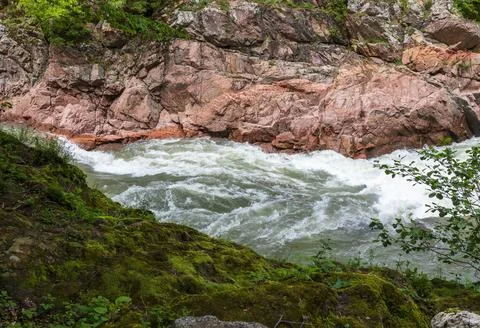 A narrow gorge through which a river flows, the sun's rays break through the Stock Photos