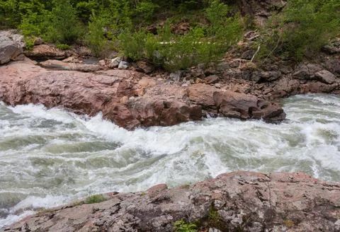 A narrow gorge through which a river flows, the sun's rays break through the Stock Photos