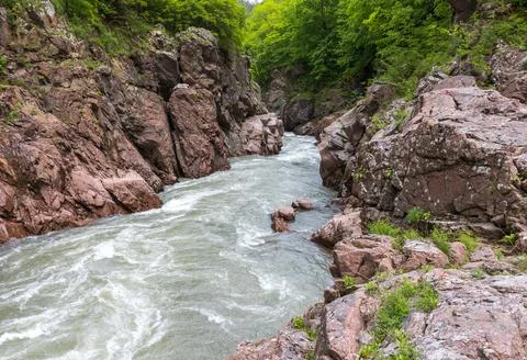 A narrow gorge through which a river flows, a rapid stream rushes through the Stock Photos