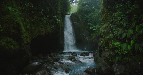 Narrow gorge waterfall at Blue Falls in Costa Rica flowing into bright blue Stock-Footage 341297917
