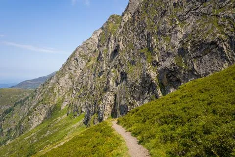 Narrow hiking path below steep Pyrenees cliffs Stock Photos