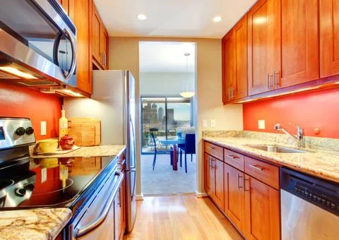 Narrow kitchen interior with orange back splash and granite tops Stock Photos