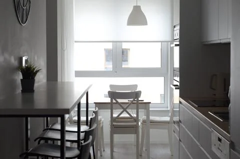 Narrow kitchen with poor lighting. Modern moninalist white studio kitchen Stock Photos