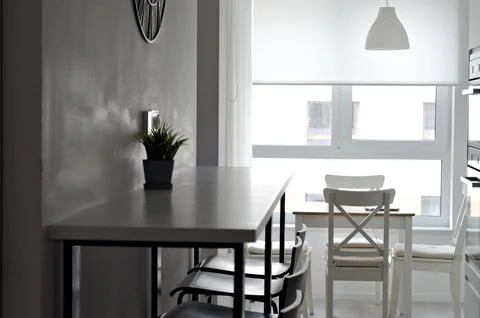 Narrow kitchen with poor lighting. Modern moninalist white studio kitchen Stock Photos