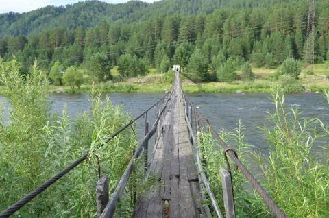 Narrow long bridge over a river in Taiga Forest, Siberia, Russia Stock Photos